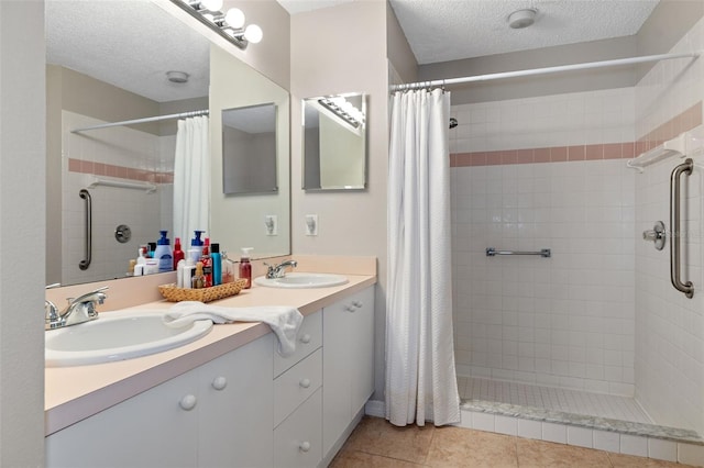 bathroom with vanity, a textured ceiling, tile patterned floors, and a shower with shower curtain