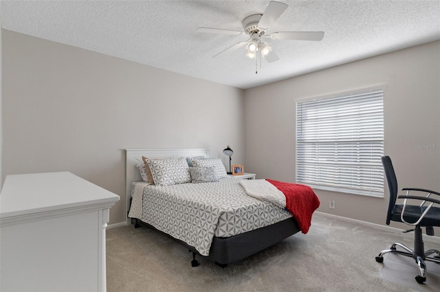 carpeted bedroom featuring ceiling fan and a textured ceiling