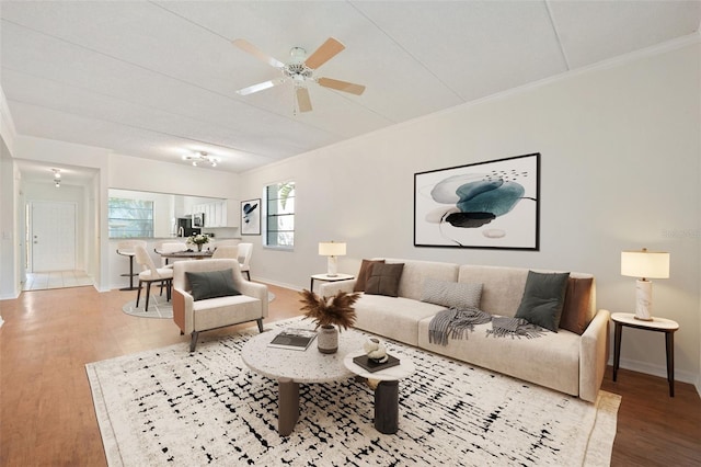 living room with hardwood / wood-style floors, ceiling fan, and ornamental molding