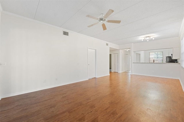 unfurnished living room featuring hardwood / wood-style floors, ceiling fan, and crown molding