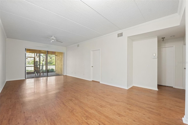 empty room with ceiling fan, light hardwood / wood-style flooring, a textured ceiling, and ornamental molding