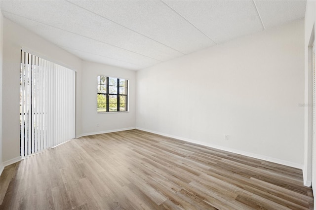 spare room featuring a textured ceiling and light hardwood / wood-style flooring