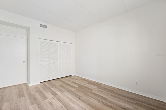 unfurnished bedroom with a closet and light hardwood / wood-style flooring