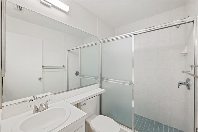 bathroom with vanity, toilet, and a shower with shower door