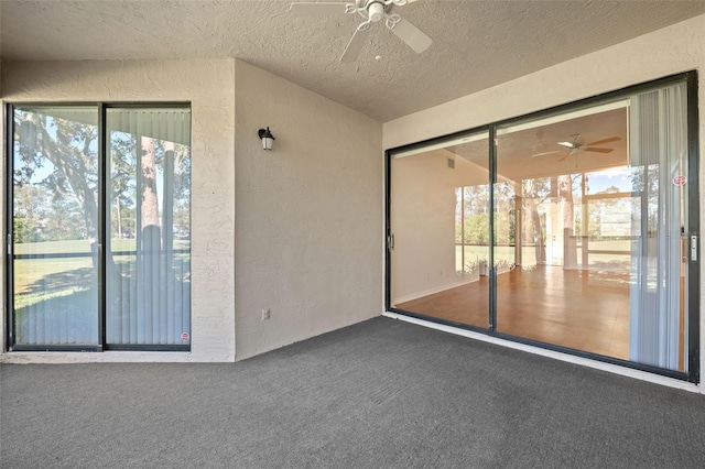 interior space featuring carpet, a textured ceiling, and ceiling fan