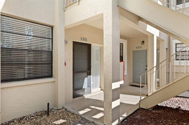 entrance to property featuring stucco siding