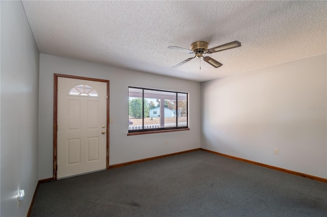 carpeted foyer entrance featuring ceiling fan and a textured ceiling