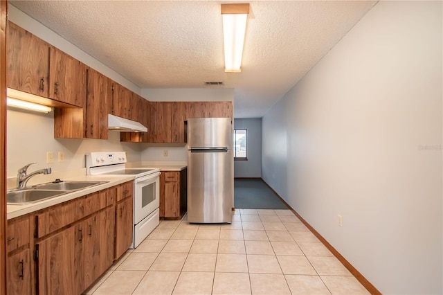 kitchen featuring stainless steel fridge, a textured ceiling, sink, white electric range, and light tile patterned flooring