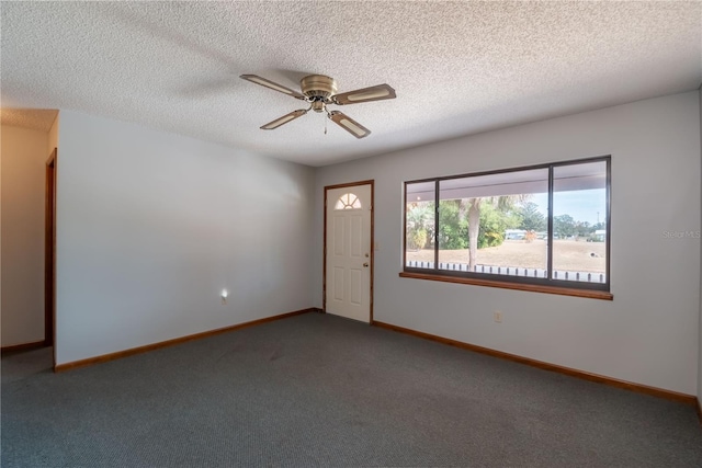 carpeted empty room featuring ceiling fan and a textured ceiling