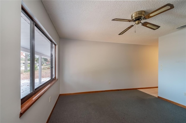 carpeted empty room with ceiling fan and a textured ceiling