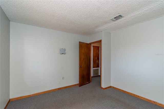 carpeted spare room featuring a textured ceiling