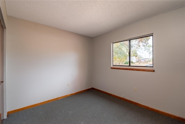 unfurnished room with carpet and a textured ceiling