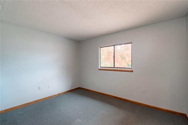 carpeted empty room featuring a textured ceiling