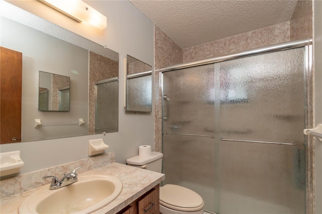 bathroom featuring a textured ceiling, vanity, toilet, and an enclosed shower