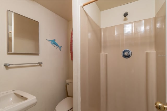 bathroom featuring walk in shower, sink, and toilet