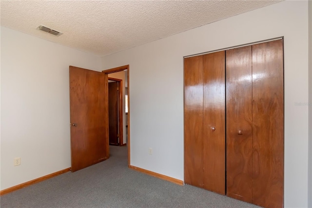 unfurnished bedroom with a textured ceiling, light carpet, and a closet