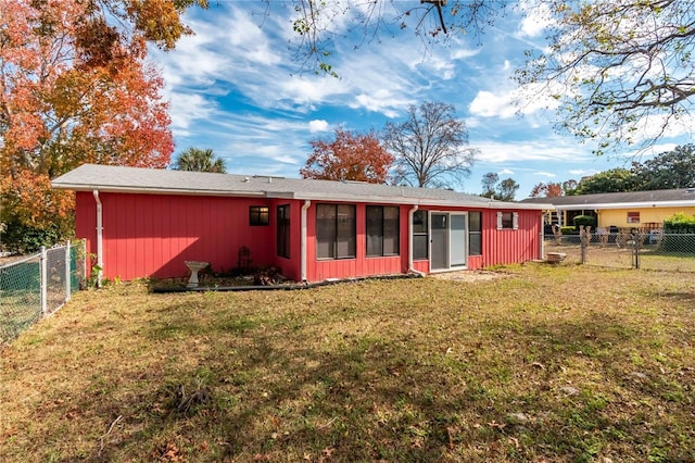 rear view of property with a sunroom and a yard