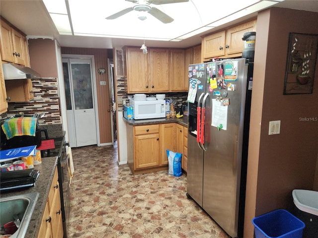 kitchen with decorative backsplash, stainless steel fridge, ceiling fan, sink, and black / electric stove