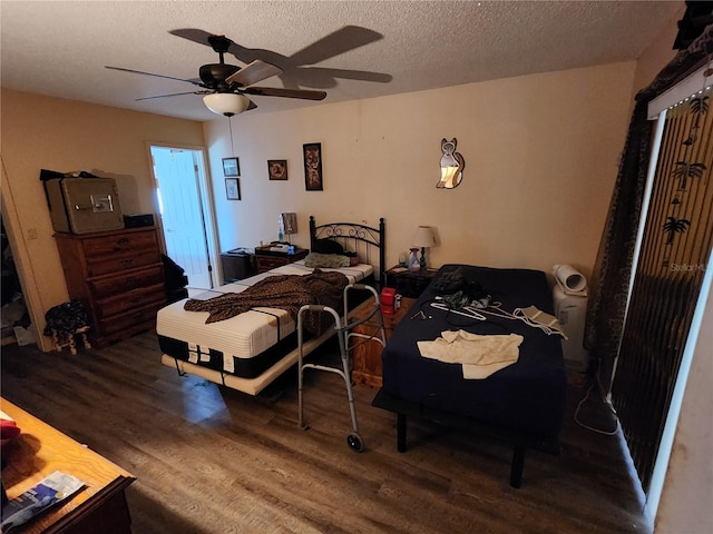 bedroom with ceiling fan, dark wood-type flooring, and a textured ceiling