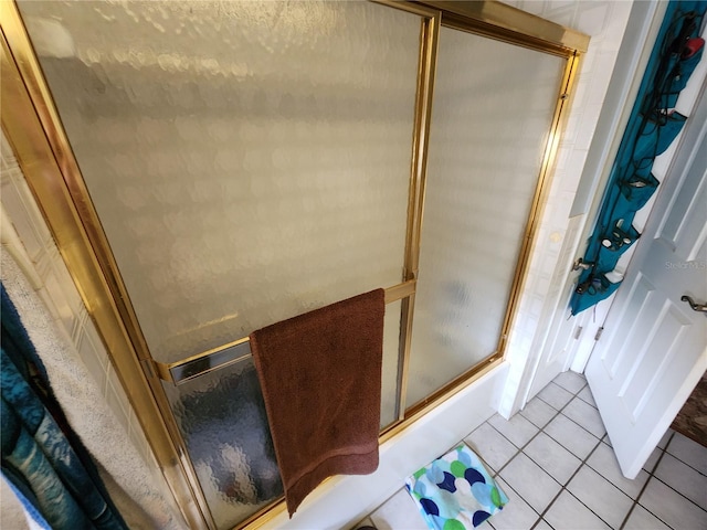 bathroom featuring tile patterned floors and shower / bath combination with glass door