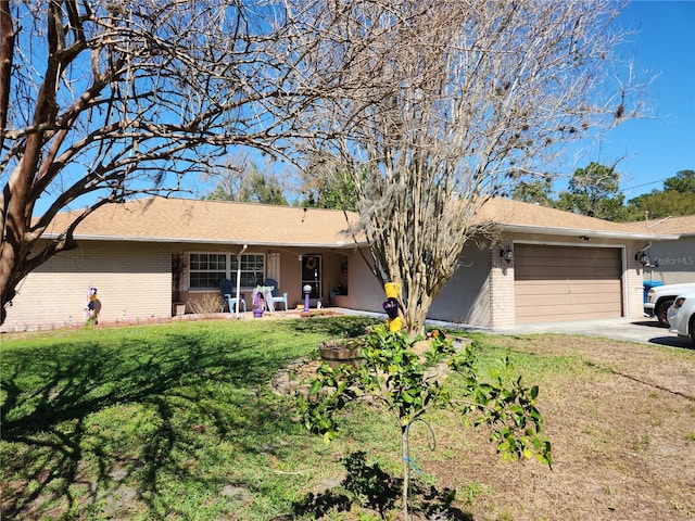 ranch-style house with driveway, brick siding, an attached garage, and a front yard