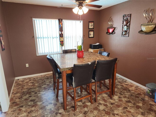 dining space with a ceiling fan and baseboards