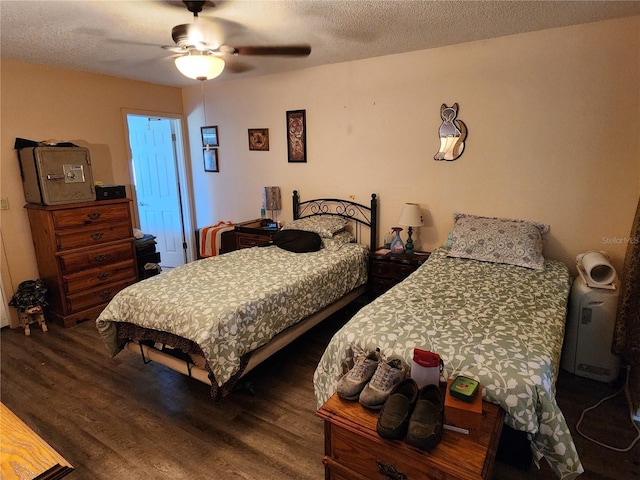 bedroom with dark wood-type flooring, a textured ceiling, and a ceiling fan