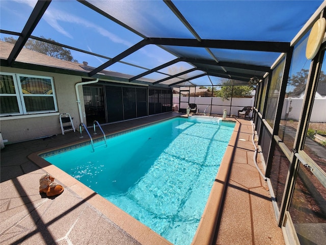 view of swimming pool featuring glass enclosure, fence, and a fenced in pool