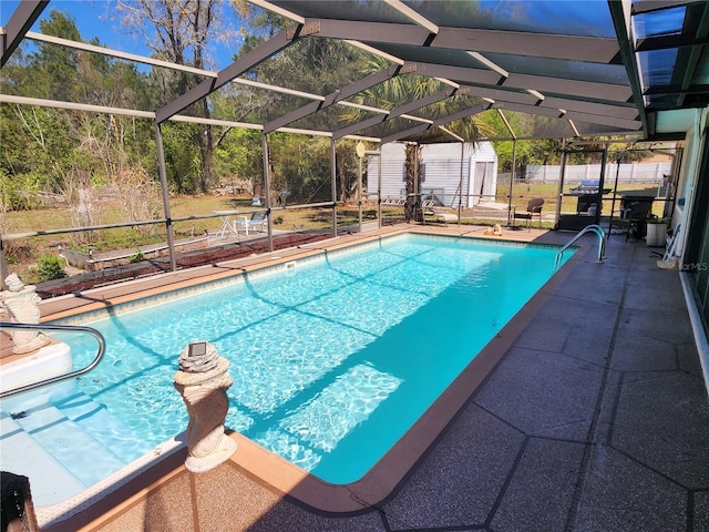 view of swimming pool with a storage shed, glass enclosure, an outbuilding, and a fenced in pool