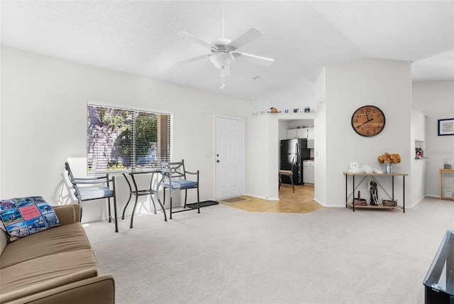 living room with a textured ceiling, light carpet, ceiling fan, and lofted ceiling