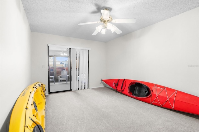 game room with carpet, ceiling fan, and a textured ceiling