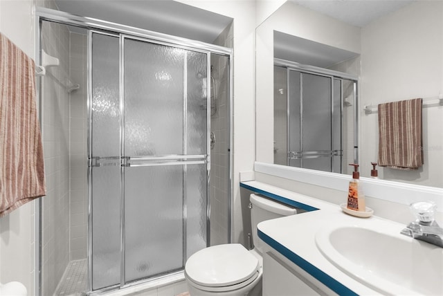 bathroom with vanity, toilet, and a shower with door