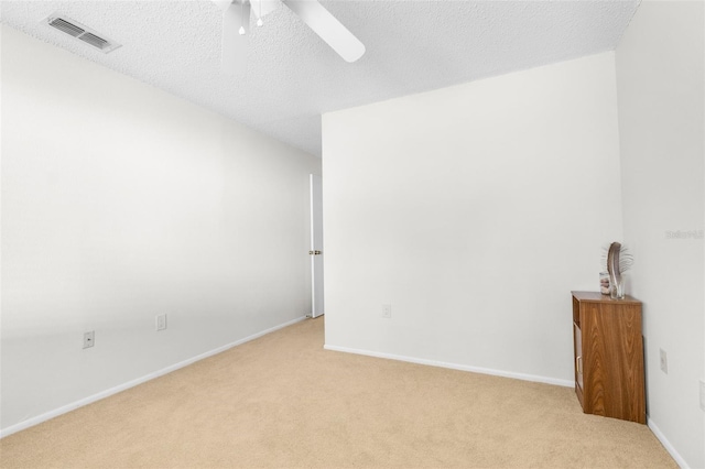 carpeted empty room featuring ceiling fan and a textured ceiling