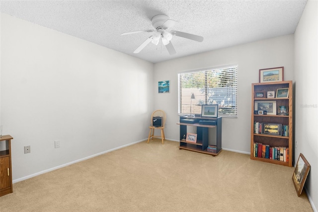 misc room with ceiling fan, light colored carpet, and a textured ceiling