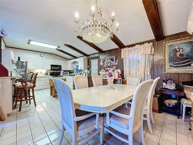 dining room with a textured ceiling, wooden walls, light tile patterned floors, an inviting chandelier, and vaulted ceiling with beams