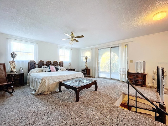 bedroom featuring access to exterior, ceiling fan, carpet floors, and a textured ceiling