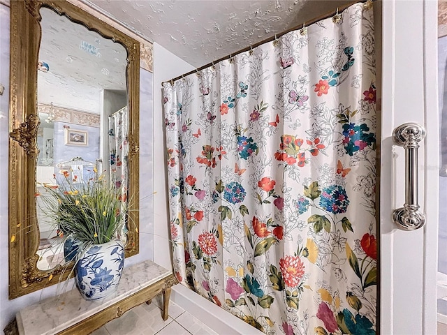 bathroom featuring tile patterned flooring and a textured ceiling