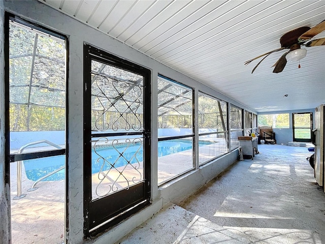 unfurnished sunroom with ceiling fan