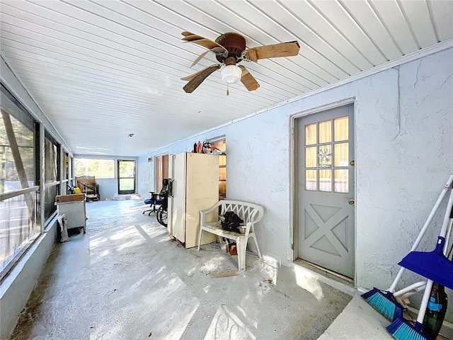 unfurnished sunroom featuring ceiling fan