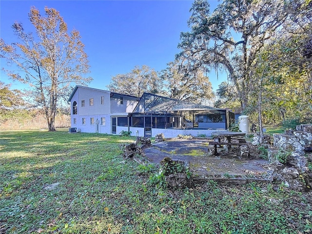 rear view of property with a lawn and a sunroom