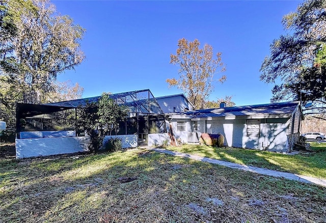 rear view of property with a yard and a lanai