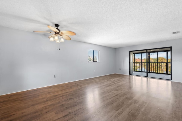 empty room featuring a textured ceiling, ceiling fan, and dark hardwood / wood-style floors