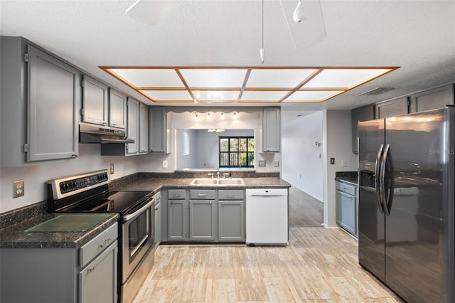 kitchen featuring sink, fridge with ice dispenser, dishwasher, light hardwood / wood-style floors, and stainless steel electric range oven