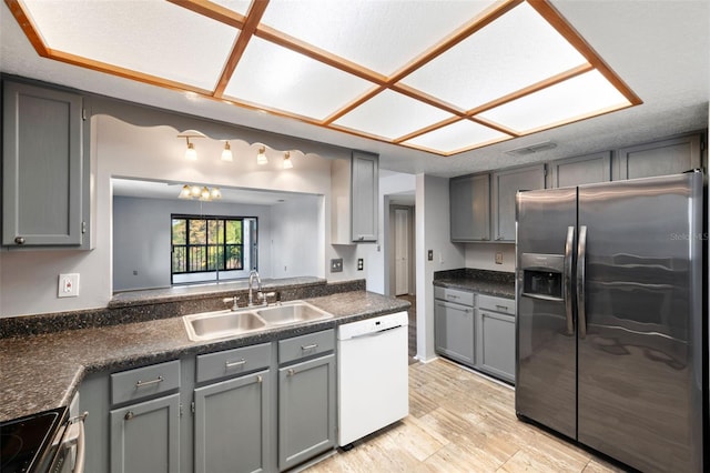 kitchen with sink, stainless steel appliances, and a textured ceiling