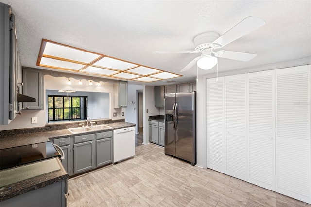 kitchen with dishwasher, stainless steel fridge, gray cabinetry, and sink