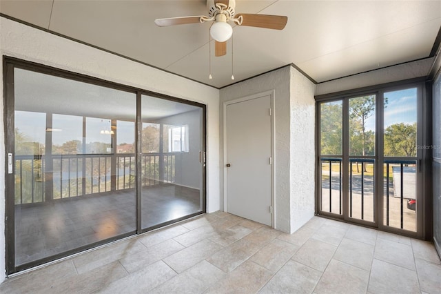 interior space with light tile patterned floors, ceiling fan, and a healthy amount of sunlight