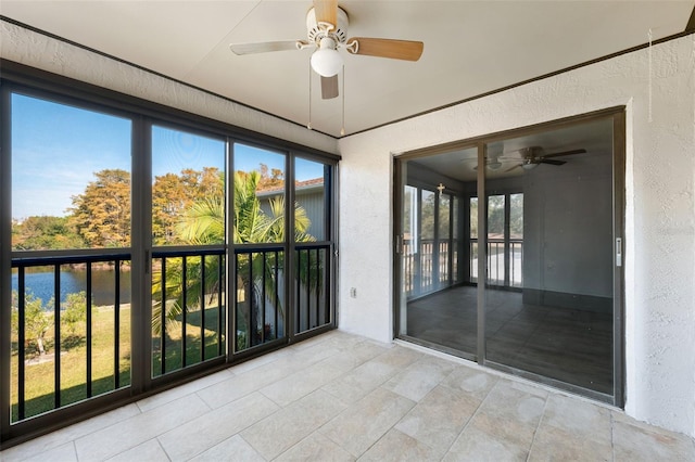 unfurnished sunroom with ceiling fan