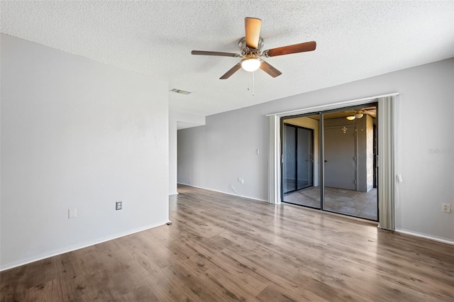 unfurnished room featuring wood-type flooring, a textured ceiling, and ceiling fan