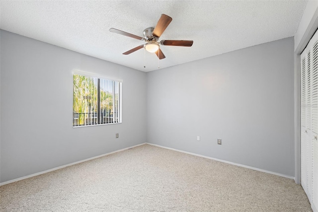 unfurnished bedroom with ceiling fan, carpet floors, a textured ceiling, and a closet