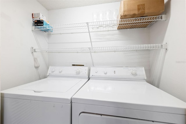 clothes washing area featuring washer and clothes dryer and a textured ceiling